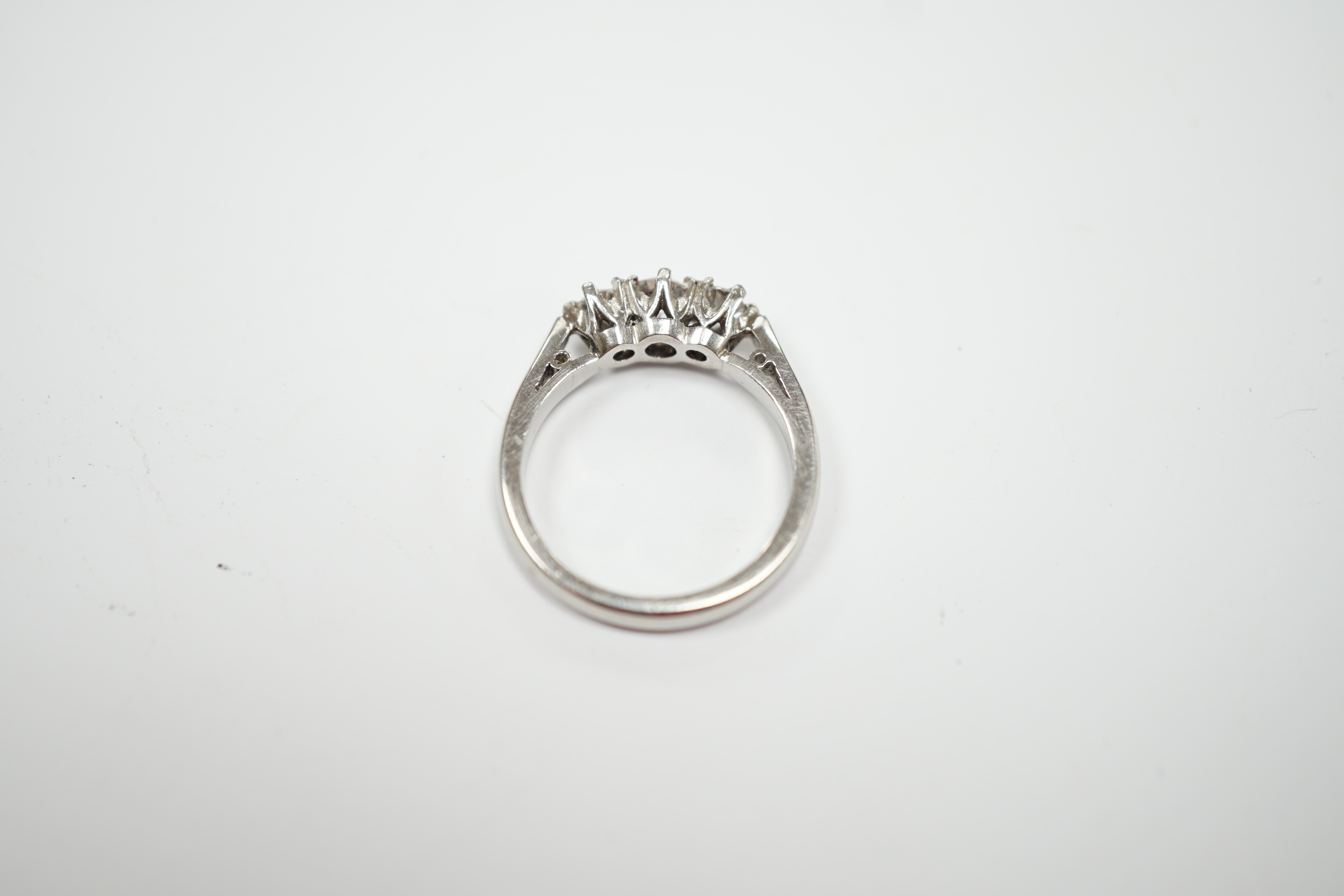 A modern platinum and three stone diamond set ring, size J, gross weight 4.6 grams.